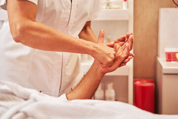 Obraz na płótnie Canvas Massage therapist pressing fist into client palm