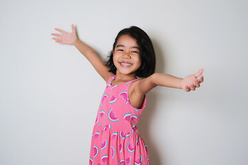 Asian little girl showing happy excited expression with her arms open
