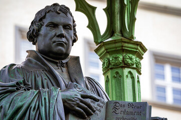 The memorial for the reformer Martin Luther on the market square in Lutherstadt Wittenberg (Saxony-Anhalt, Germany) commemorates the Reformation. Bronze figure by Johann Gottfried Schadow (1821). - obrazy, fototapety, plakaty