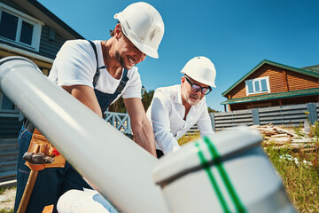 Construction workers in helmets leaning over table