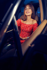Cheerful woman sitting on driver seat in car