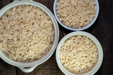 rice brown in bowl isolated on wood table