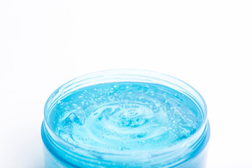 Cosmetic gel in a jar on a white background. Blue transparent gel with texture and bubbles isolate