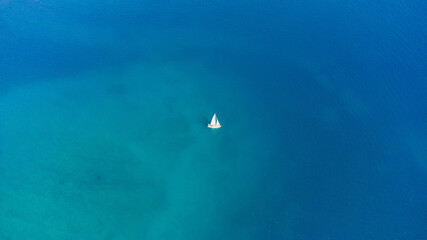 Fototapeta na wymiar Drone aerial view of a sailing boat on a blue ocean sea waters.
