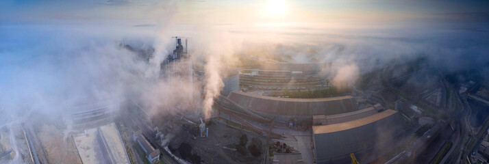 Industrial plant at sunrise in the fog