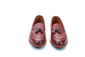 Traditional Formal Stylish Brown Pebble Grain Tassel Loafer Shoes On White Reflective Surface.