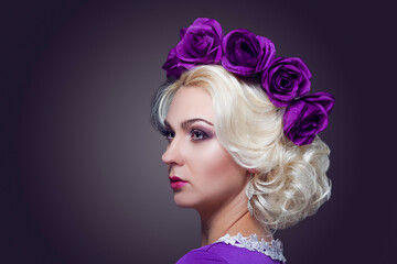 Fashion and Beauty Concepts. Portrait of Blond Caucasian Female With Purple Flowery Crown Against Black