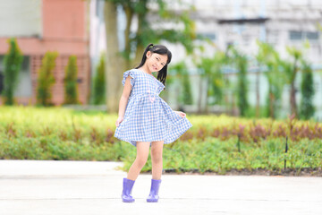 Asian kid girl happy in the park garden tree background, Beautiful child having fun playing outside with happy smile children playing outdoors little girl portrait wear colorful boots