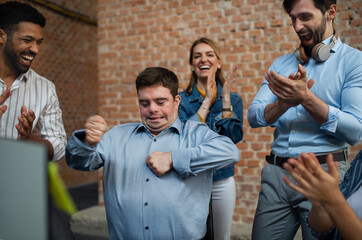 Cheerful young businesspeople having fun in office, social inclusion and cooperation concept.