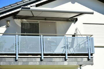 Moderner Balkon mit Edelstahl-Geländer und Metall-Sichtschutzplatten an Neubau-Hausfront