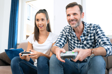 Couple playing games on console, gamepad in hands