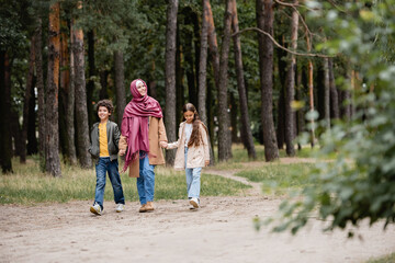 Obraz premium Arabian mother and kids walking in park
