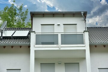 Moderner Balkon mit Edelstahl-Sichtschutz und Edelstahl-Geländer an einer Neubau-Hausfront