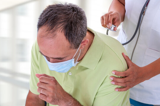 patient caughing while female doctor examinating him