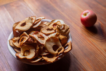 Ripe fresh healthy diet vegetarian food with vitamins. Dried apples in the form of rings on a plate on a wooden surface. Harvesting season.