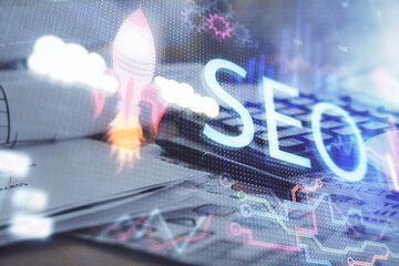 Multi exposure of SEO drawings and desk with open notebook background. Concept of Search...