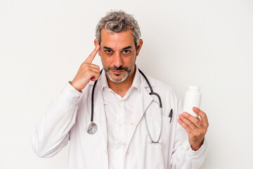 Middle age doctor caucasian man isolated on white background  pointing temple with finger, thinking, focused on a task.