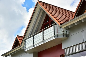 Moderner Balkon mit Sichtschutz aus Mattglasplatten und Metall-Geländer an einer Neubau-Hausfront