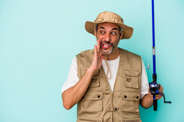 Middle age caucasian fisherman holding rod isolated on blue background  is saying a secret hot braking news and looking aside