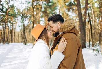 Husband and wife hug each other in the winter forest