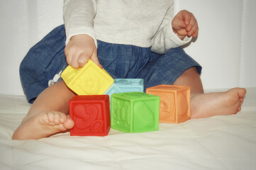 the child plays with colored cubes. children's hands and feet.