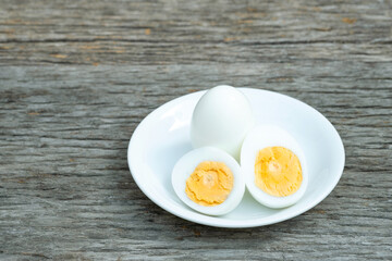 boiled eggs. Boiled eggs in white ceramic plate on wooden table.