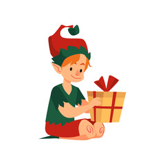 Cute christmas boy elf helper santa claus sit on floor with holiday present.