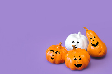 Pumpkins With  Funny Faces On Violet Background, Creative Concept.  Modern Trendy Halloween Composition. Festive Advertising Still Life, Front View. Decor For Celebration. Copy Space For Text.