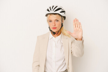 Young business Russian woman holding bike helmet isolated on white background standing with outstretched hand showing stop sign, preventing you.