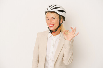 Young business Russian woman holding bike helmet isolated on white background cheerful and confident showing ok gesture.