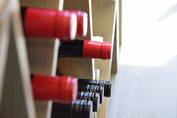 Wine bottles on wooden shelf in wine store