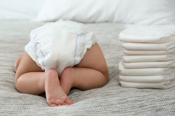 Cute little baby in diaper on bed - obrazy, fototapety, plakaty