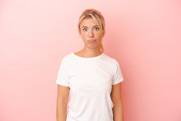 Fototapeta premium Young Russian woman isolated on pink background sad, serious face, feeling miserable and displeased.
