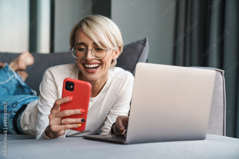 Wall mural Smiling mid aged blonde woman using mobile phone