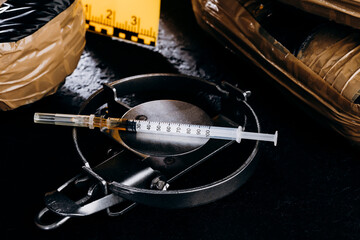 Heroin in a syringe on the dark cement floor. An addictive substance, a drug, an illegal thing, the...