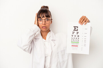 Young mixed race optician woman doing a test isolated on white background  being shocked, she has...