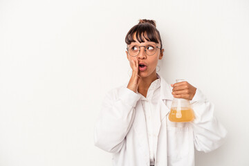 Young mixed race scientist woman holding a test tube isolated on white background  is saying a...