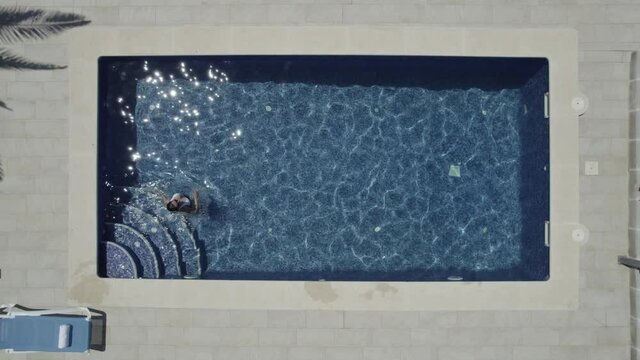 Mujer saliendo de piscina escaleras 4(Formato D-log para edici&oacute;n profesional)