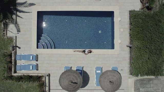 Mujer al borde de la piscina tumbada(Formato D-log para edici&oacute;n profesional)