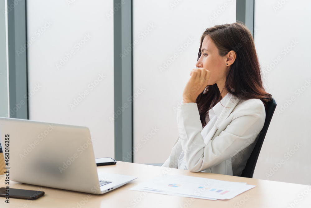 Wall mural Adult smart business woman sitting on the working desk and thinking about work in modern office room