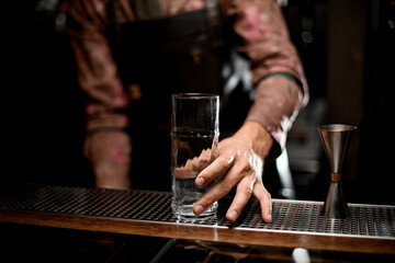 beautiful clean transparent tall glass and steel jigger on the bar counter