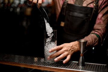 Clear tall glass in which poured crushed ice from scoop