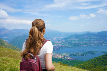 Naklejka premium Female hiker relaxing and enjoying landscape after trekking on mountains from belvedere