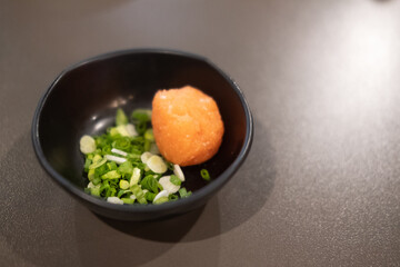 Orange grated radish with chopped spring ready for mix with ponzu.
