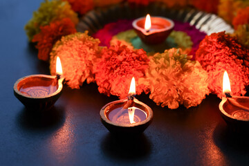 Diwali celebration Indian festival of lights Diya oil lamp and colors Rangoli decoration bright colorful  flowers flowerbed copy space greetings Dipavali Hindu festival North India, Mumbai Delhi India © sanirimpan
