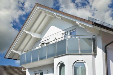 Moderner Balkon mit Sichtschutz aus Mattglasplatten und Metall-Geländer an einer Neubau-Hausfront © Hermann