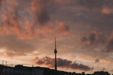 Obraz premium Purple cloudy sunset sky. Baku, Azerbaijan. Tower in Baku on the sunset. High quality photo