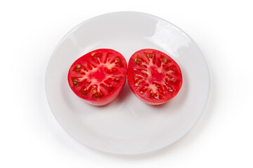 Two halves of pink tomato on a white dish