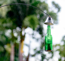 up cycled green bottle as a candle  holder hang in the park.