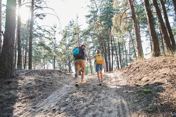 Father walking with daughter on path in forest